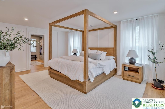 bedroom with recessed lighting and wood finished floors