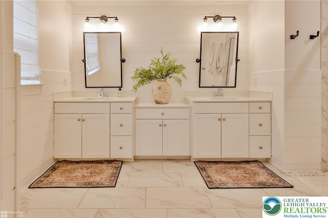 full bathroom featuring marble finish floor and vanity