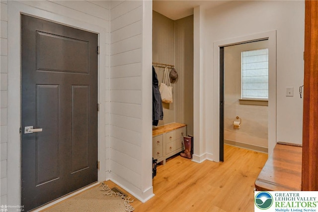 foyer with light wood-style flooring and baseboards
