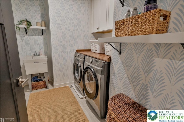 washroom with independent washer and dryer, cabinet space, baseboards, and wallpapered walls