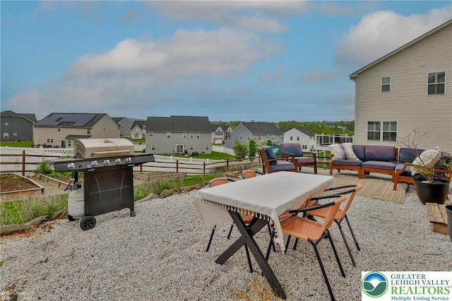 view of patio featuring an outdoor living space, outdoor dining space, area for grilling, fence, and a residential view