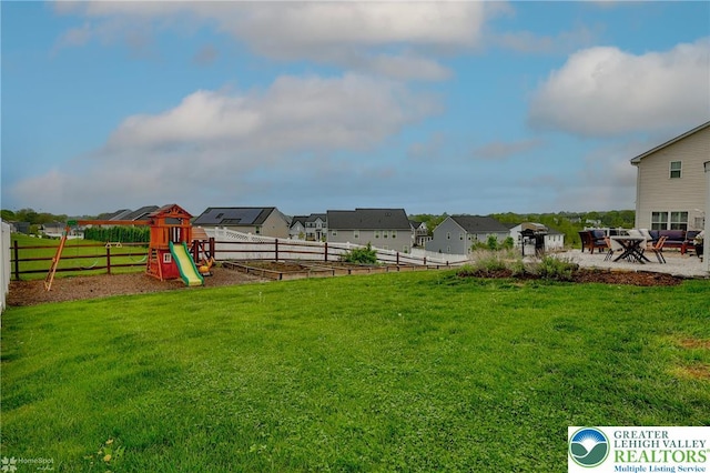 view of yard with fence, a playground, a patio area, and a residential view