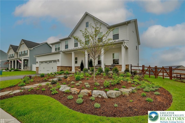 view of front of property featuring fence, stone siding, a residential view, a garage, and a front lawn