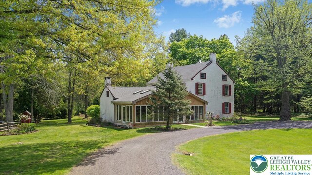 8043 Richlandtown Rd, East Rockhill Twp, PA 18951 - view of front of house with a chimney, a sunroom, a front yard, and curved driveway