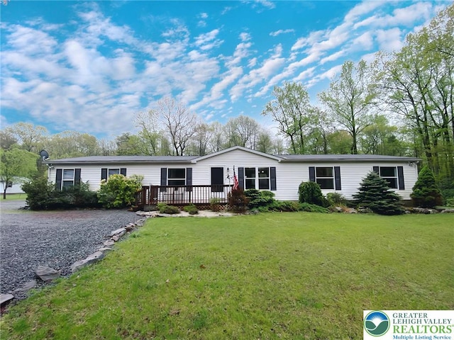 view of front of property with a wooden deck and a front yard