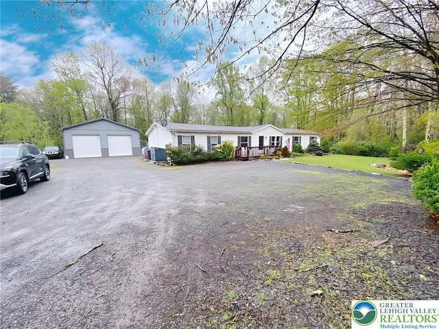 single story home with a garage, an outdoor structure, and a deck