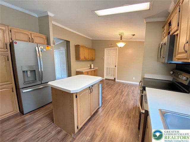 kitchen with appliances with stainless steel finishes, a center island, crown molding, wood finished floors, and light countertops