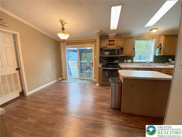 kitchen with appliances with stainless steel finishes, light countertops, a sink, crown molding, and backsplash