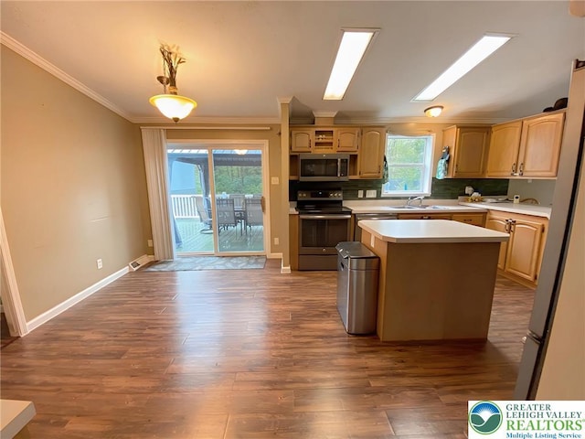 kitchen with stainless steel appliances, light countertops, crown molding, a sink, and a center island