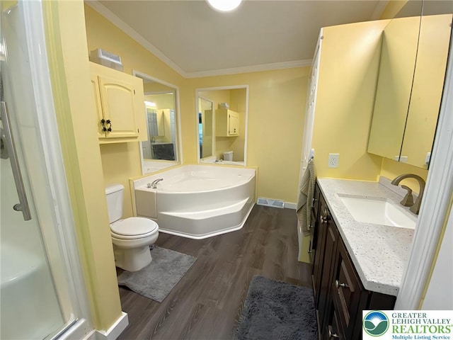 bathroom with wood finished floors, ornamental molding, toilet, a garden tub, and vanity