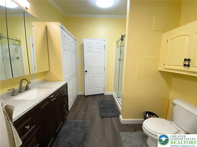 full bathroom with wood finished floors, toilet, a shower stall, crown molding, and vanity