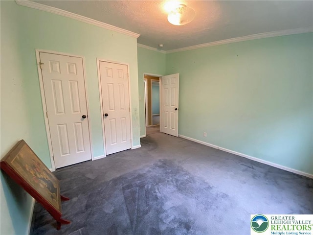 unfurnished bedroom featuring ornamental molding, carpet, baseboards, and a textured ceiling