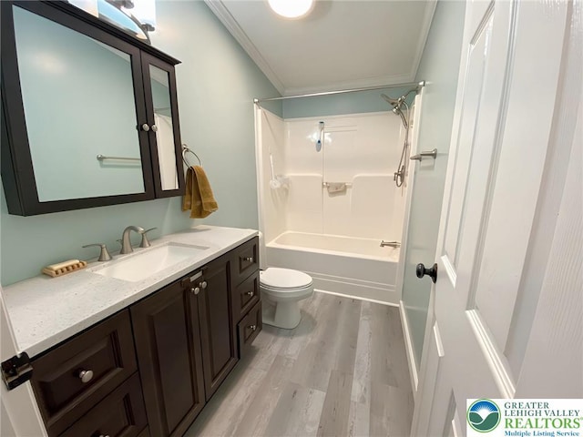 full bathroom featuring wood finished floors, toilet, vanity, ornamental molding, and shower / bath combination