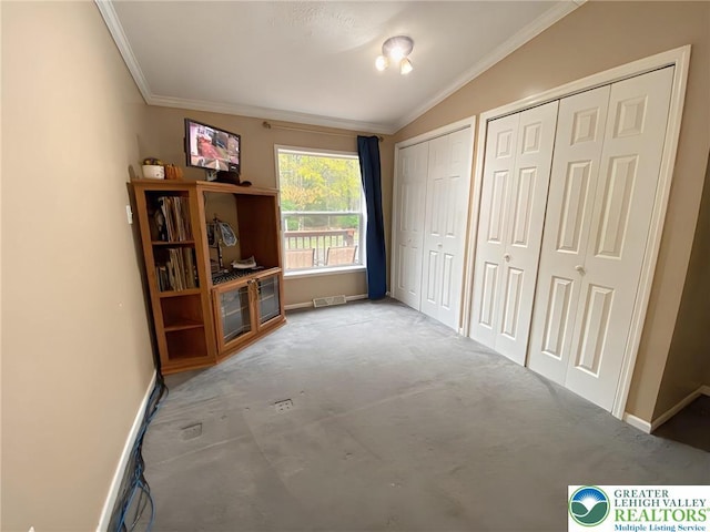 unfurnished bedroom featuring two closets, ornamental molding, lofted ceiling, baseboards, and carpet