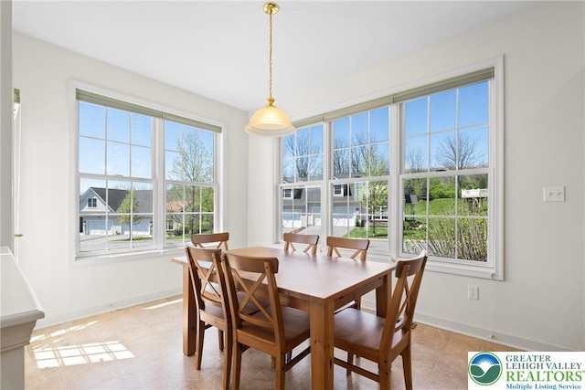 dining space featuring baseboards and light tile patterned floors