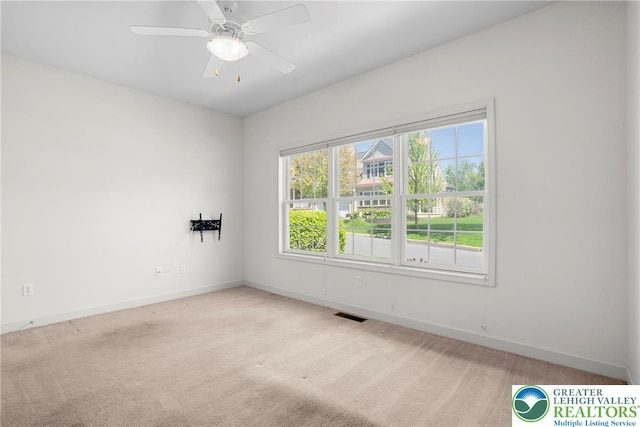 unfurnished room with baseboards, light colored carpet, and a ceiling fan