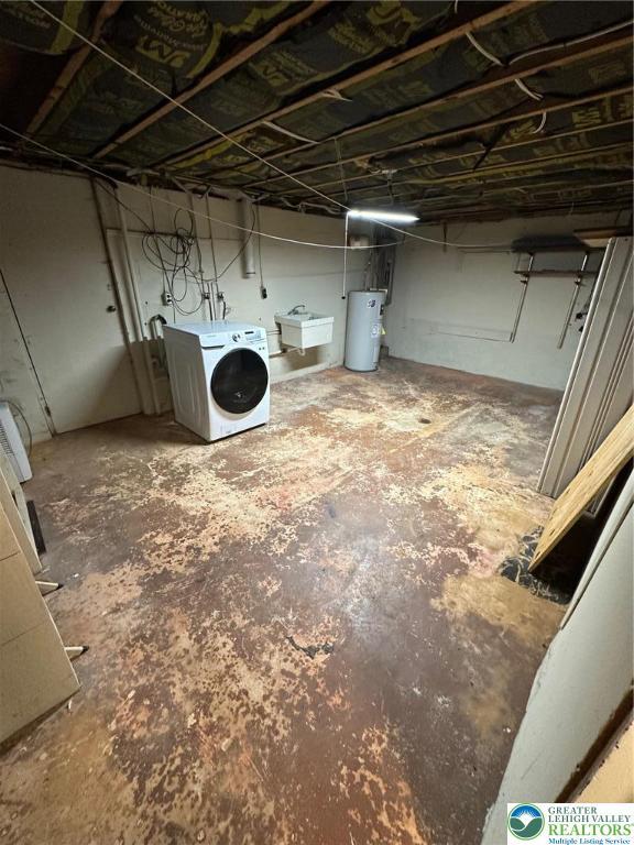 unfinished below grade area featuring washer / dryer, electric water heater, and a sink