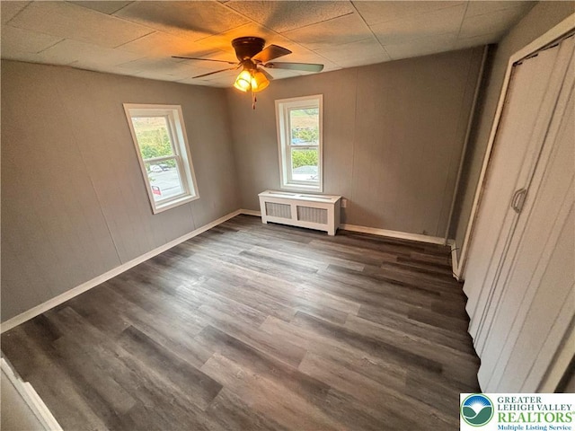 121 E Ridge St, Coaldale Borough, PA 18218 - unfurnished bedroom with radiator, multiple windows, dark wood-type flooring, and baseboards