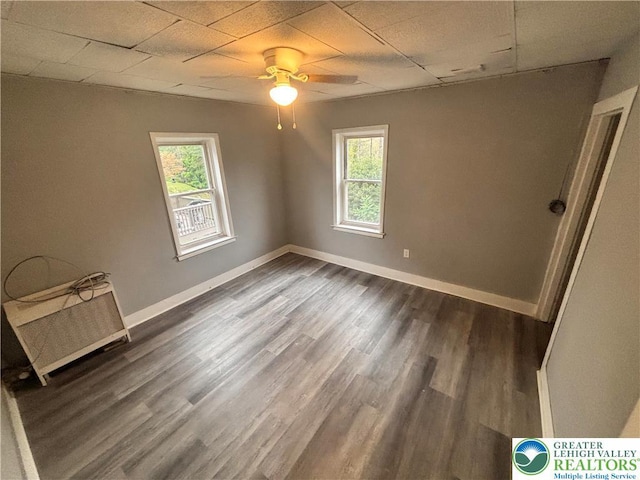 121 E Ridge St, Coaldale Borough, PA 18218 - empty room featuring a ceiling fan, plenty of natural light, dark wood-type flooring, baseboards, and a paneled ceiling