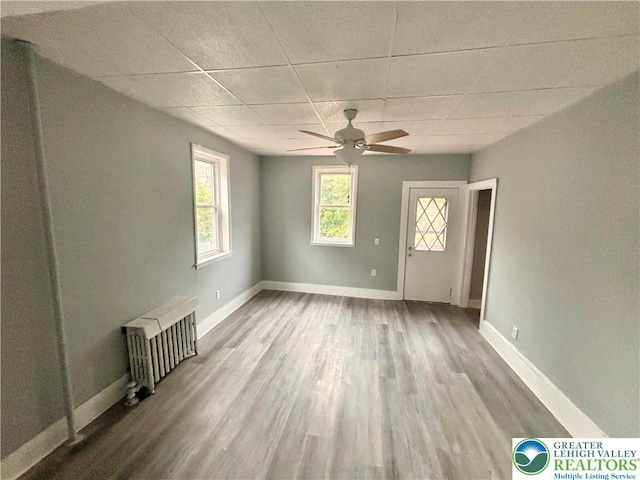 121 E Ridge St, Coaldale Borough, PA 18218 - empty room with radiator, a ceiling fan, a paneled ceiling, wood finished floors, and baseboards