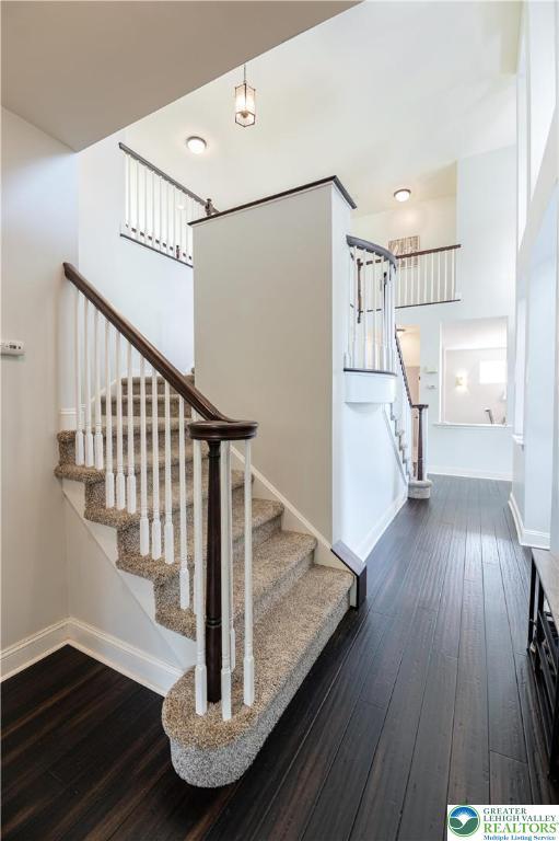 staircase with hardwood / wood-style floors and baseboards