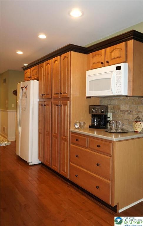 kitchen featuring white appliances, dark wood finished floors, light countertops, tasteful backsplash, and recessed lighting