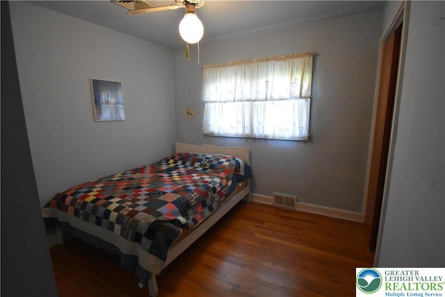 bedroom featuring wood finished floors, baseboards, and a ceiling fan