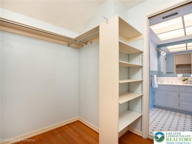spacious closet with wood finished floors and lofted ceiling