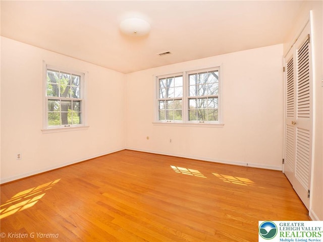 unfurnished bedroom with light wood-style flooring, baseboards, and a closet