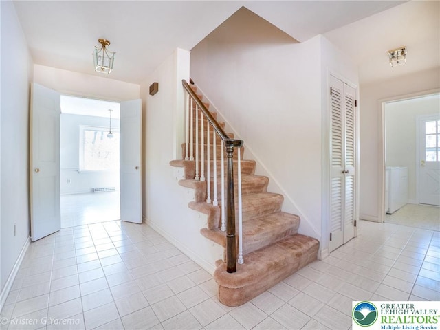 stairway with washer / clothes dryer, tile patterned floors, and baseboards