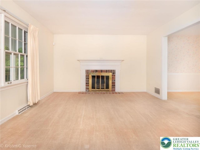 unfurnished living room featuring carpet, a fireplace, and baseboards