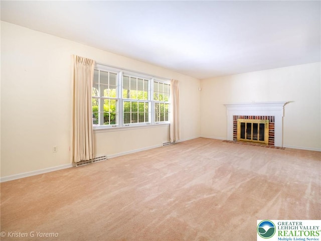 unfurnished living room with carpet floors, a fireplace, and baseboards