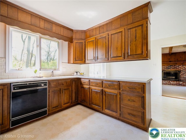 kitchen with dishwasher, light floors, light countertops, and decorative backsplash