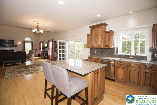 2690 Greens Dr, Lower Saucon Twp, PA 18055 - kitchen featuring stainless steel dishwasher, a sink, light wood finished floors, tasteful backsplash, and light stone counters