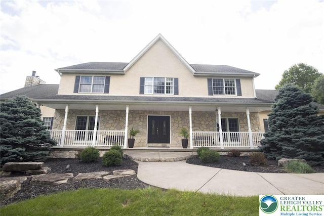 2690 Greens Dr, Lower Saucon Twp, PA 18055 - colonial-style house with covered porch, stone siding, a chimney, and stucco siding
