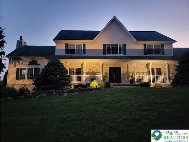 2690 Greens Dr, Lower Saucon Twp, PA 18055 - view of front of property with covered porch, a lawn, stone siding, stucco siding, and a chimney