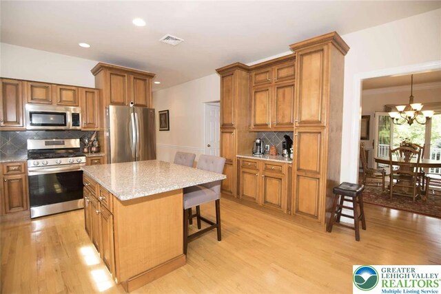 2690 Greens Dr, Lower Saucon Twp, PA 18055 - kitchen with stainless steel appliances, a kitchen breakfast bar, a chandelier, a kitchen island, and backsplash