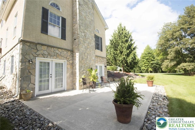 2690 Greens Dr, Lower Saucon Twp, PA 18055 - rear view of house with stone siding, french doors, a patio, a yard, and stucco siding