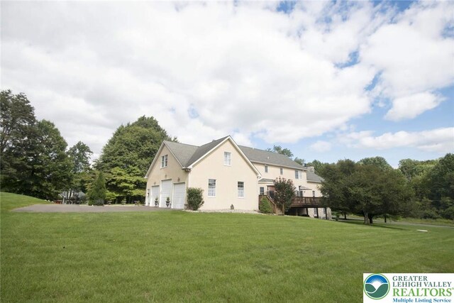 2690 Greens Dr, Lower Saucon Twp, PA 18055 - view of property exterior with a garage, stucco siding, and a yard