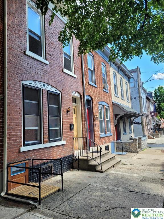 townhome / multi-family property featuring brick siding