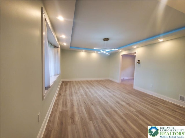 spare room featuring baseboards, recessed lighting, and wood finished floors