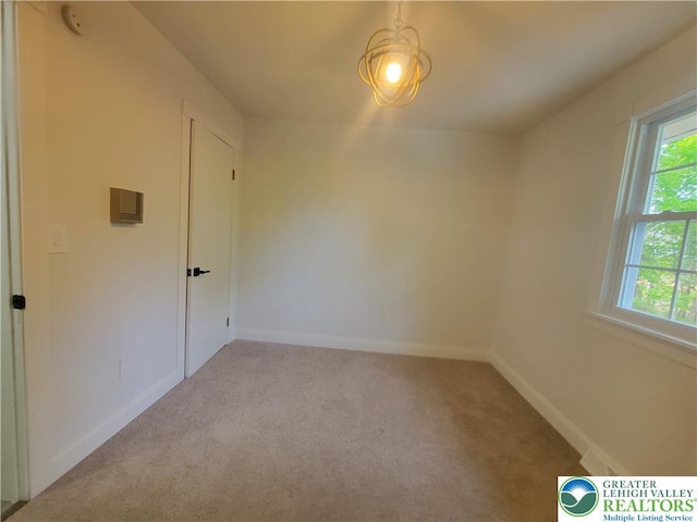 carpeted spare room with baseboards