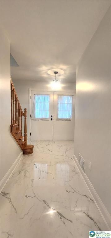 empty room with baseboards, stairs, and marble finish floors