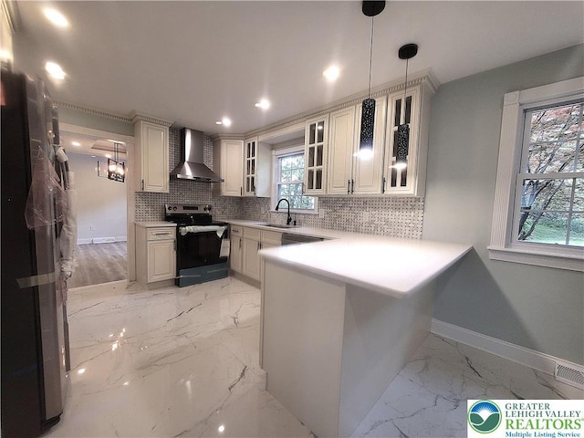 kitchen with stainless steel electric range, wall chimney range hood, light marble finish floors, a sink, and backsplash