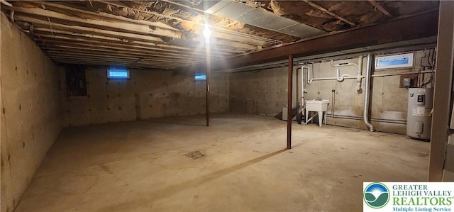 basement featuring water heater and a sink