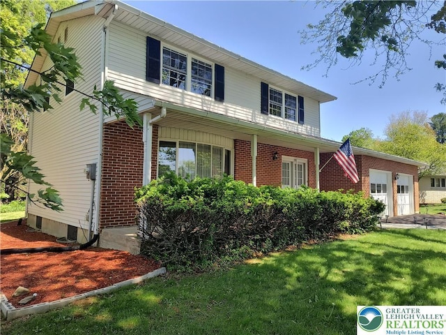 traditional home with brick siding, a garage, and a front lawn