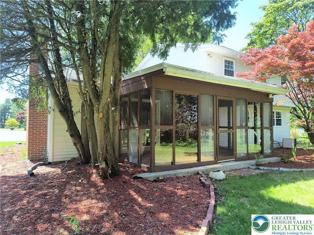 rear view of property with a sunroom