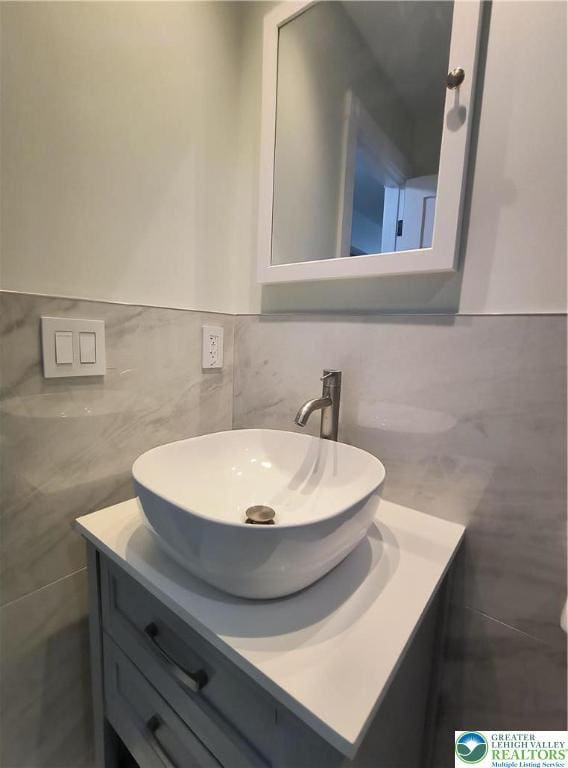 bathroom with tile walls, vanity, and wainscoting