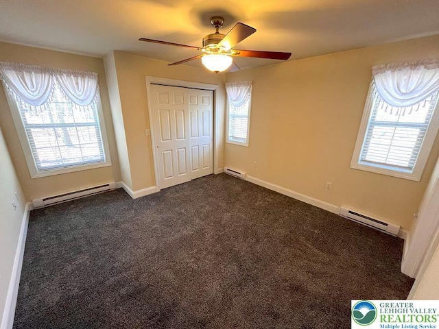 unfurnished bedroom featuring a baseboard radiator, dark colored carpet, and a closet
