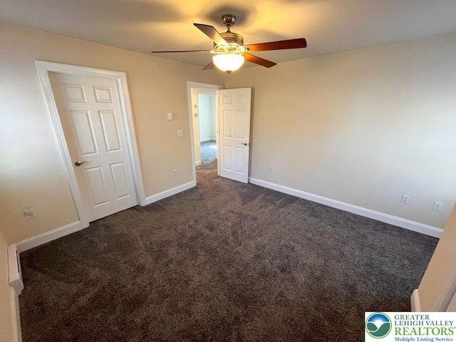 unfurnished bedroom with dark colored carpet, baseboards, and ceiling fan